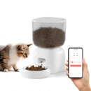 A person is using a smartphone to control an automatic pet feeder while a cat is eating from the freeder.